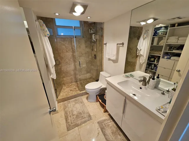 a bathroom with a sink a toilet a mirror and shower