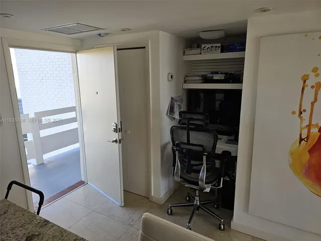 a view of a hallway with workspace and a window