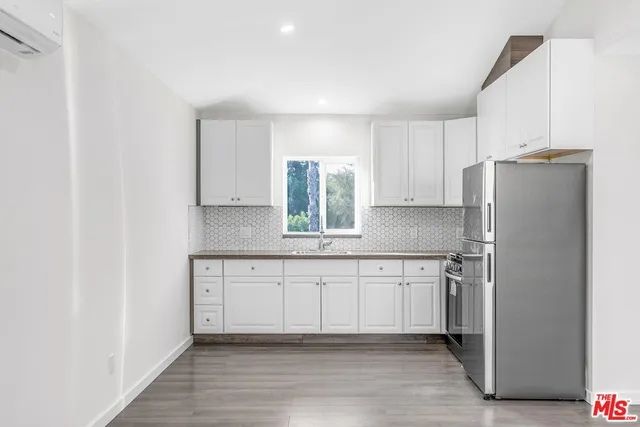a kitchen with stainless steel appliances granite countertop a refrigerator and a sink