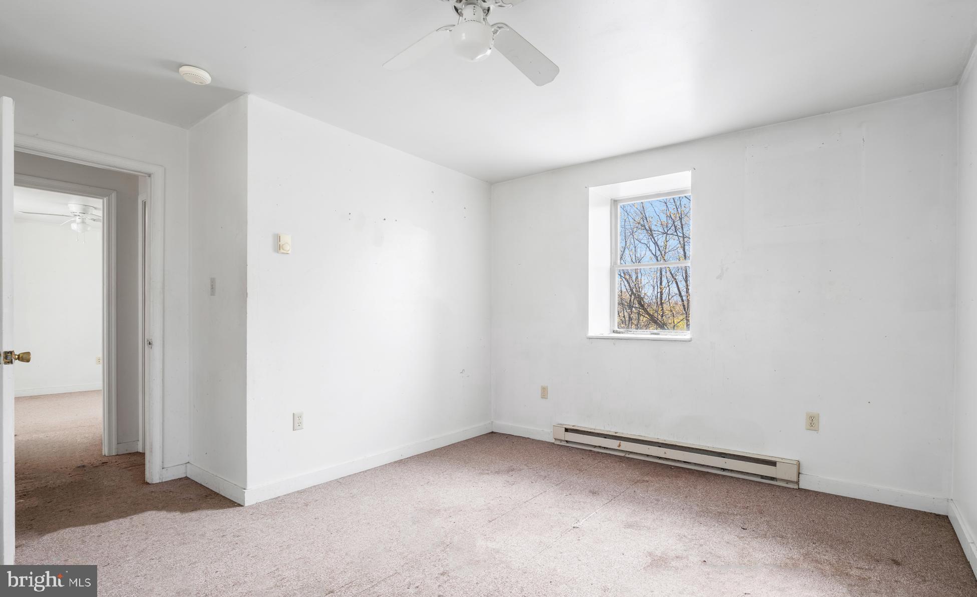 2481 Summit Point Road Summit Point, WV 25446 - Photo 25 of 35 an empty room with a ceiling fan and windows