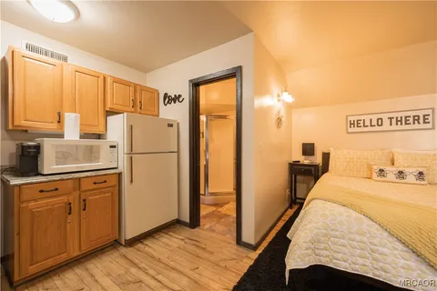 a large bedroom with a bed and wooden floor