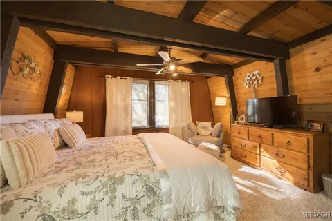 a bedroom with a bed and a flat screen tv