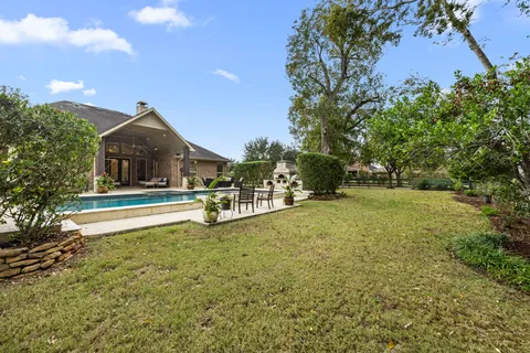 a house view with swimming pool and trees in the background
