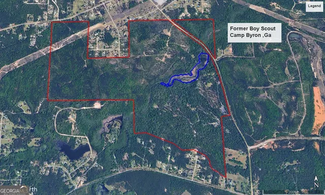 a view of a house with a yard and large tree