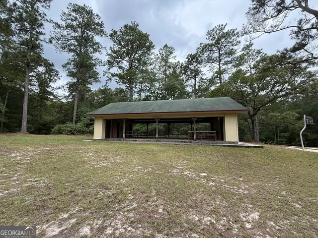 a view of a wooden house with large trees