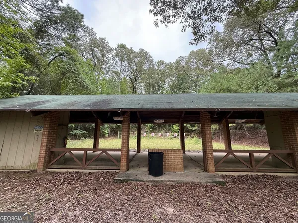 a backyard of a house with wooden fence and barbeque oven