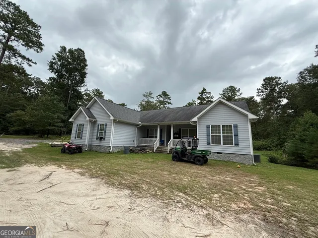 a view of a house with backyard and trees