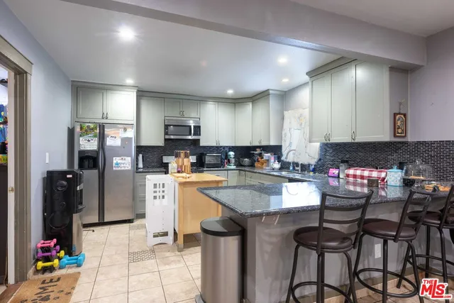 a kitchen with stainless steel appliances granite countertop a refrigerator and a stove top oven
