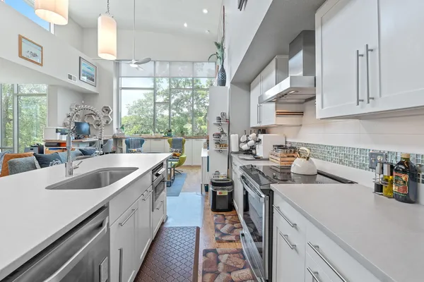 a kitchen filled counter top space a sink cabinets and a window