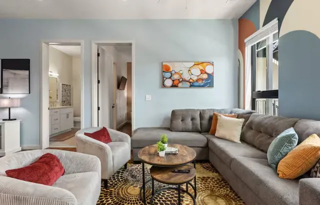 a kitchen with stainless steel appliances granite countertop a stove top oven a sink dishwasher and white cabinets with wooden floor