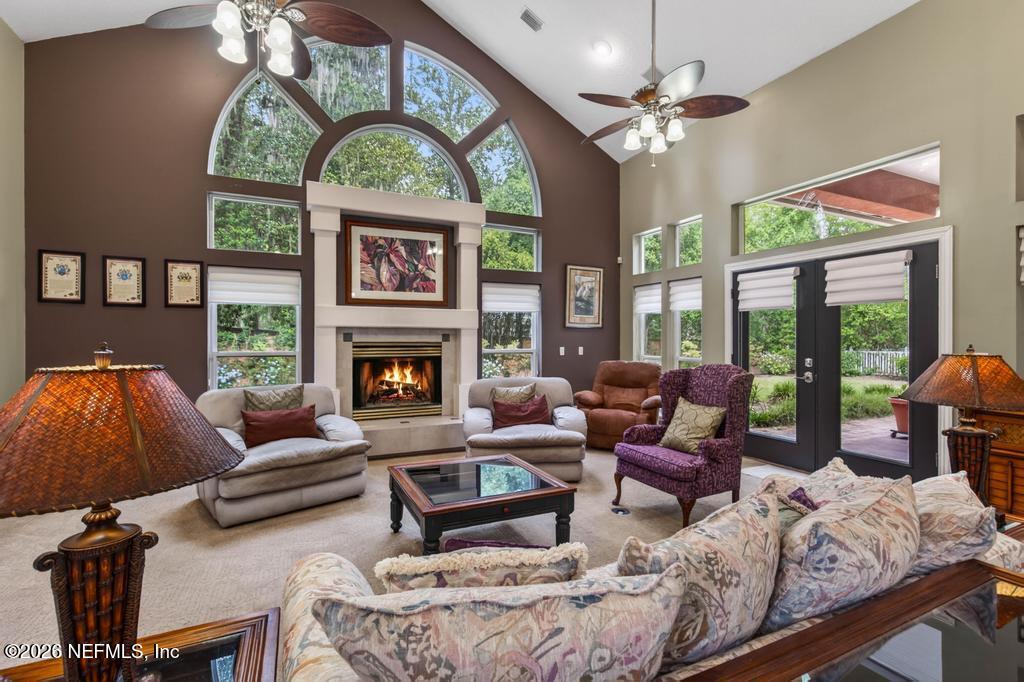 1483 Bridgette Way Fleming Island, FL 32003 - Photo 22 of 63 a living room with furniture a floor to ceiling window and a fireplace