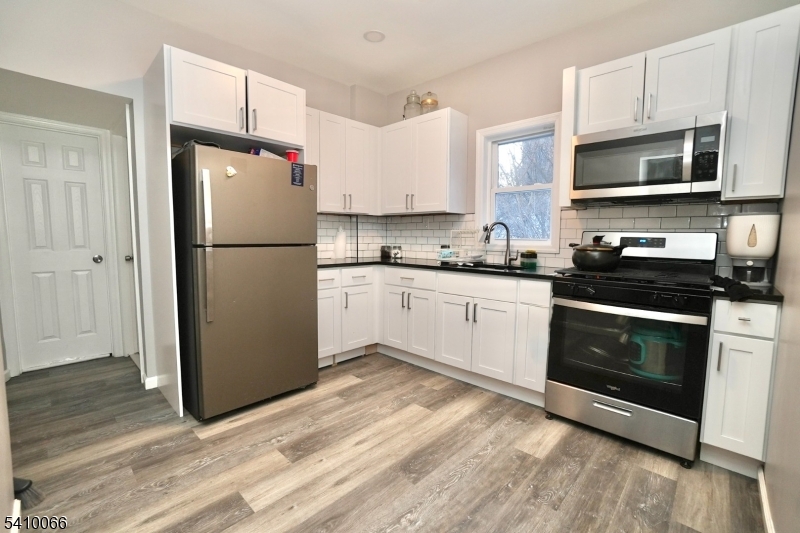 172 Delavan Avenue Newark, NJ 07104 - Photo 4 of 16 a kitchen with white cabinets and stainless steel appliances
