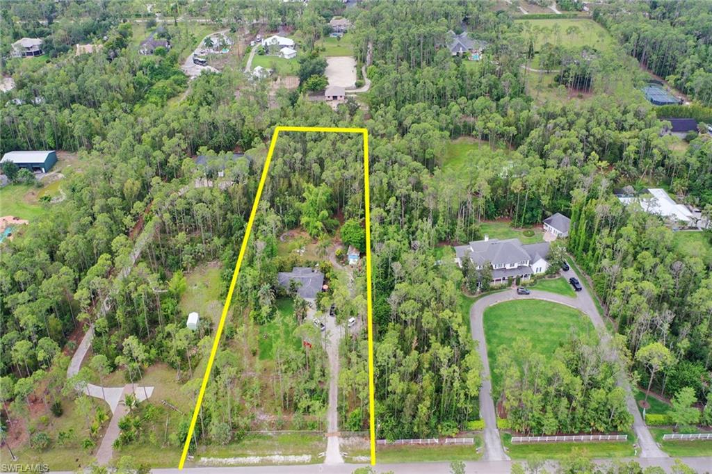 an aerial view of a residential houses with yard