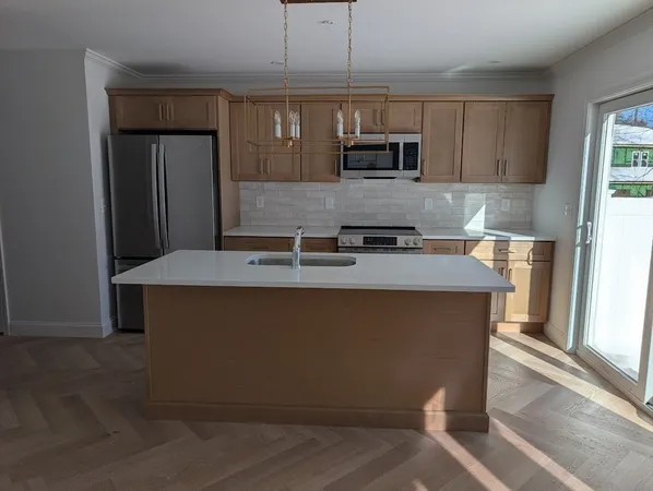 a kitchen with kitchen island granite countertop a sink and a microwave