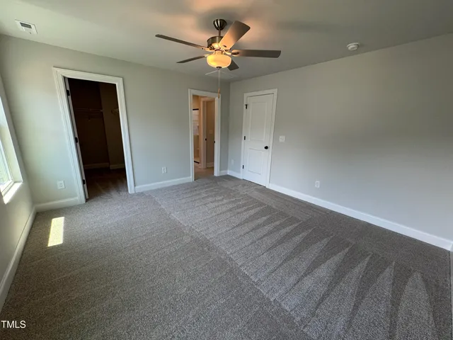 a view of an empty room with a ceiling fan