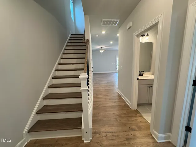 a view of hallway with stairs and wooden floor