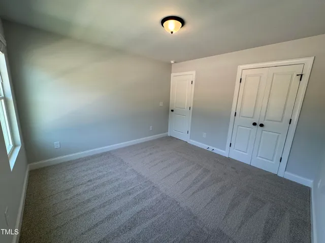 an empty room with wooden floor and mirror