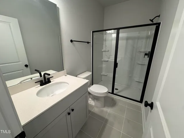 a bathroom with a sink mirror toilet and shower