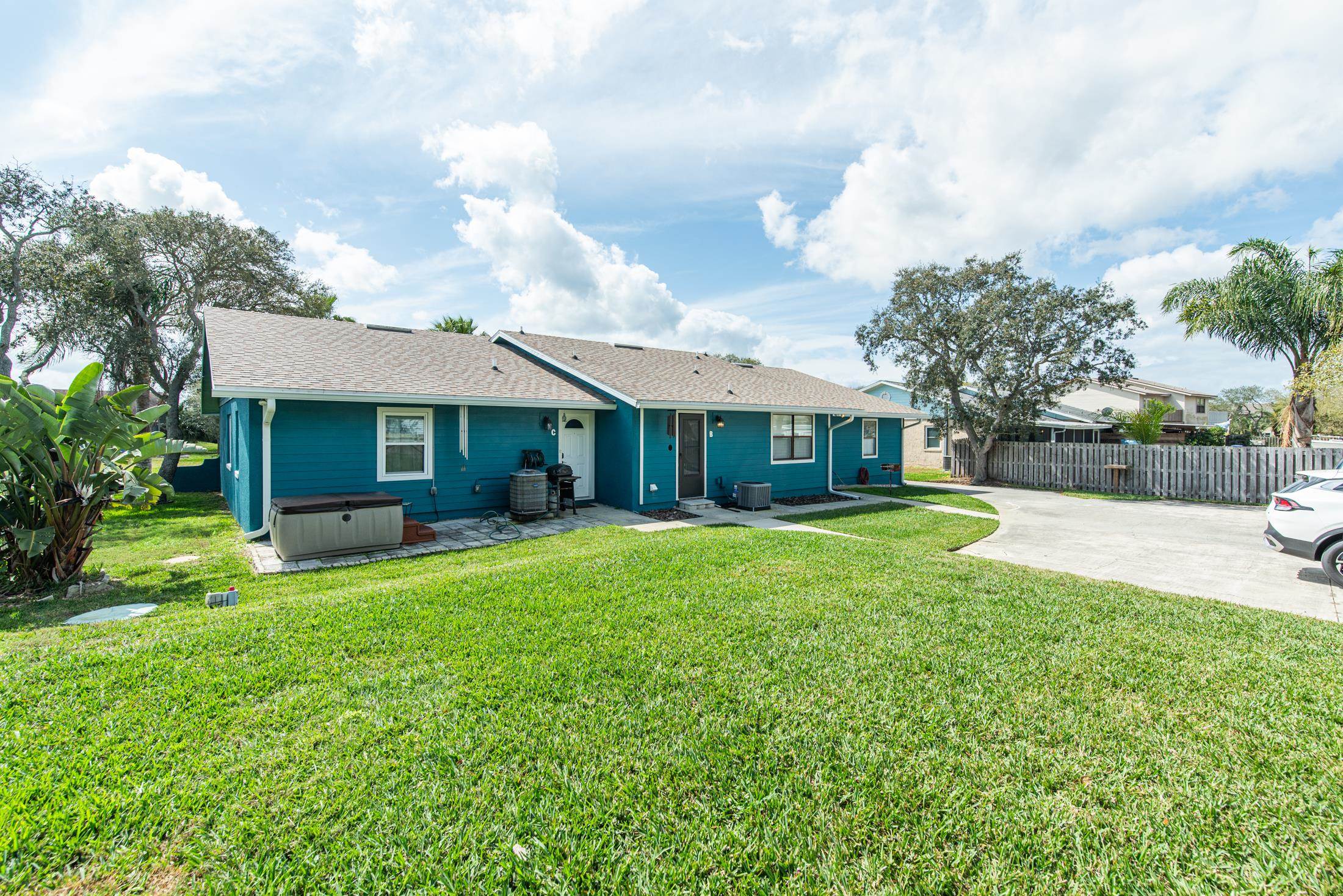 126 Rio Del Mar Street, Unit B St. Augustine, FL 32080 - Photo 20 of 24 a view of a house with a yard and a large tree