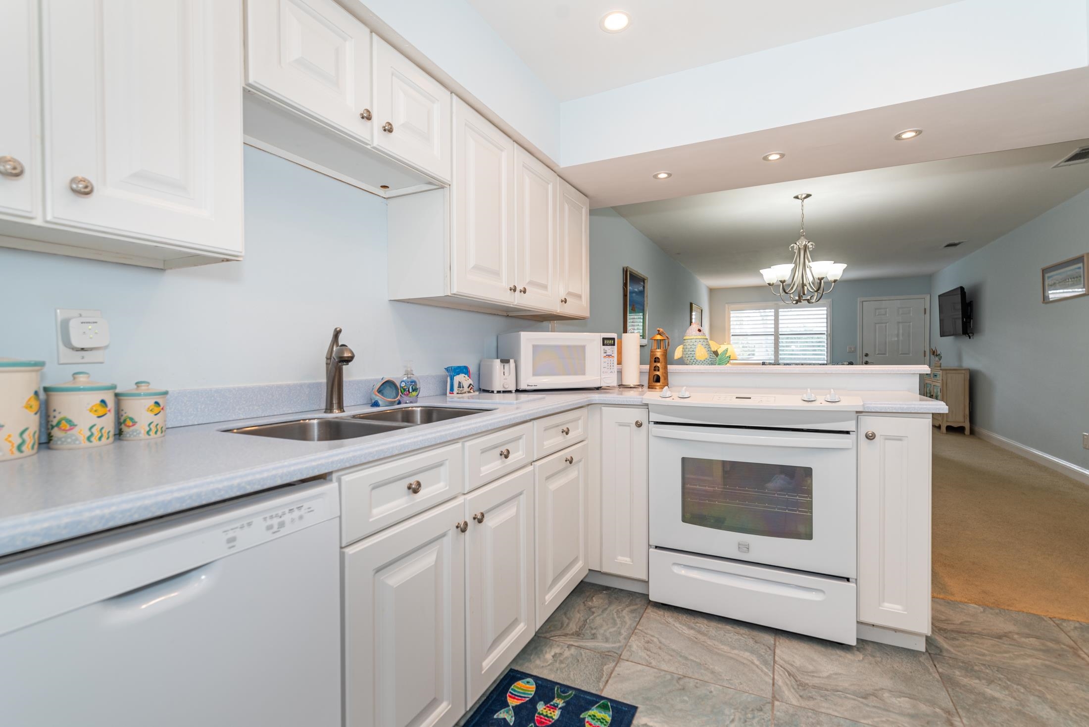 126 Rio Del Mar Street, Unit B St. Augustine, FL 32080 - Photo 10 of 24 a kitchen with white cabinets and white appliances