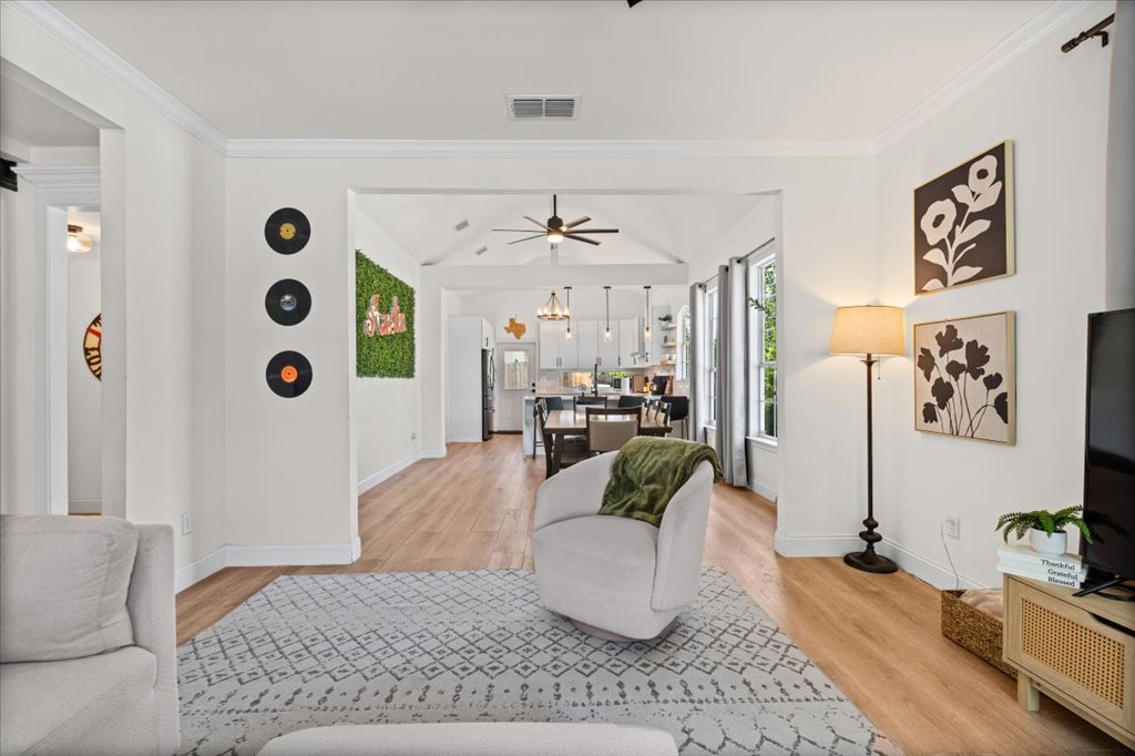 1201 Garden Street, Unit A Austin, TX 78702 - Photo 5 of 30 Open-concept interior featuring wood-finish flooring, vaulted ceilings, and crown molding