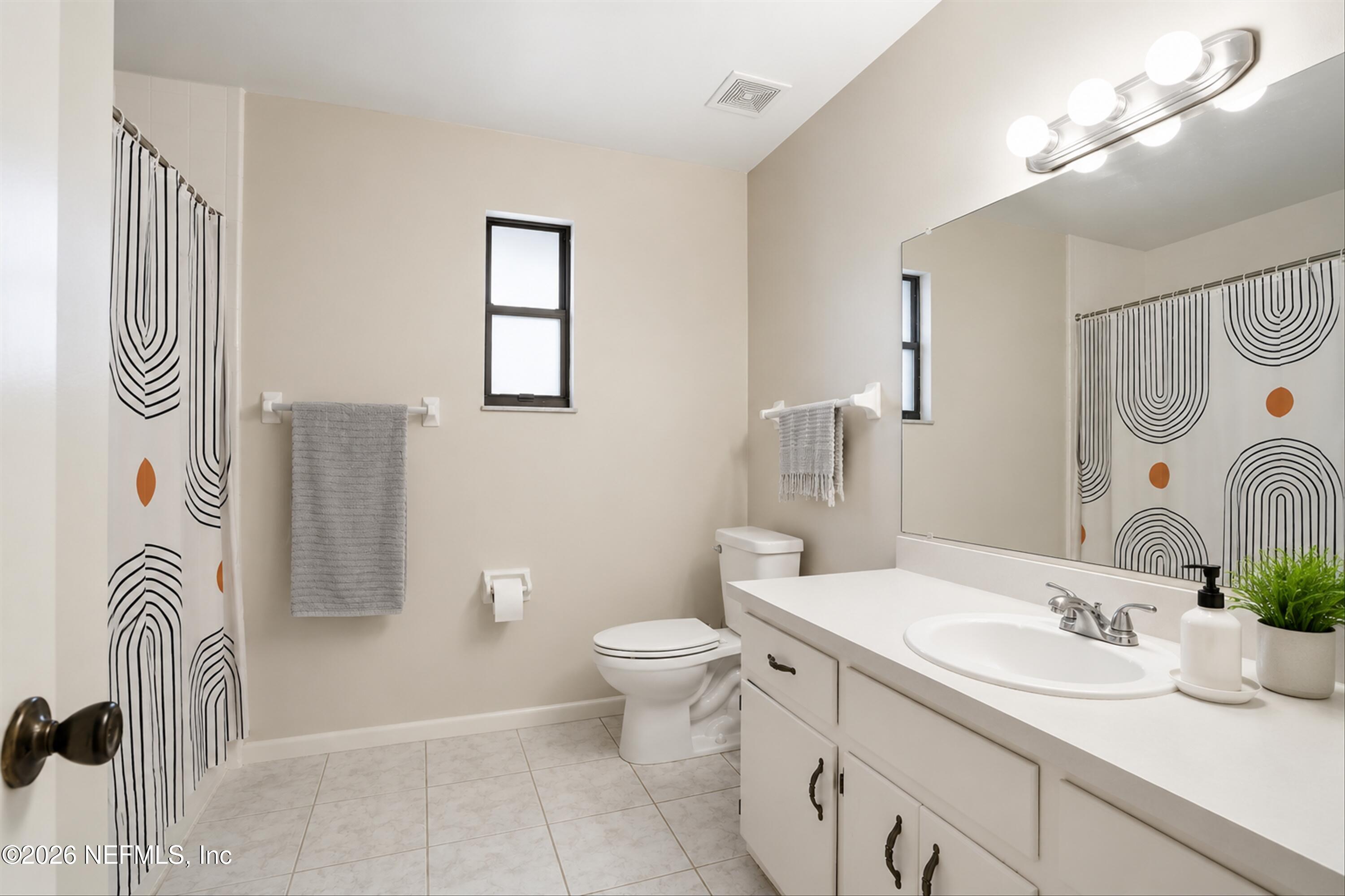 124 Hopkins Street Neptune Beach, FL 32266 - Photo 14 of 44 a bathroom with a sink a toilet and a mirror