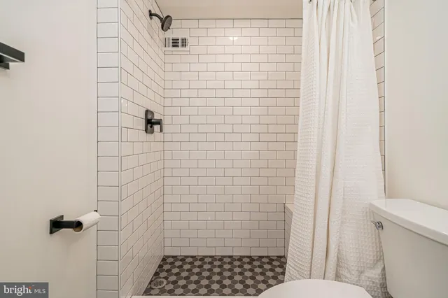 a bathroom with a toilet and shower