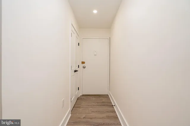 a view of a hallway with wooden floor