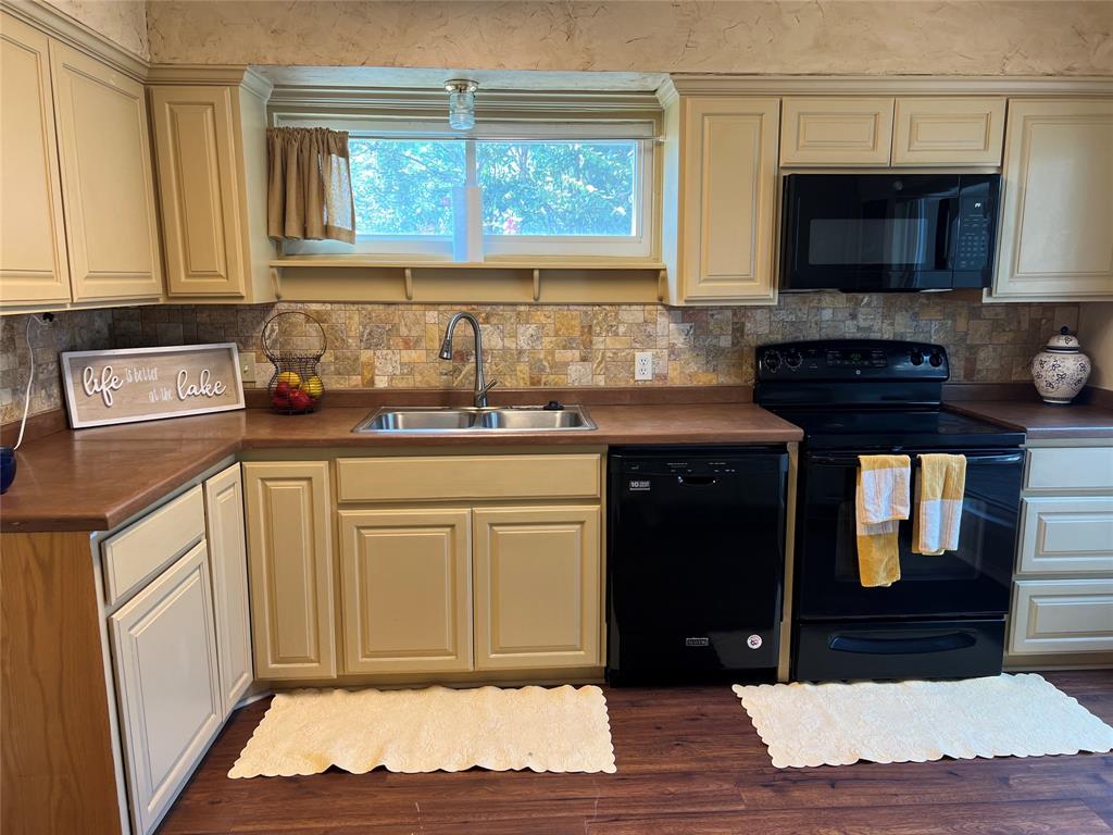 696 Harbor Drive North Azle, TX 76020 - Photo 23 of 40 a kitchen with stainless steel appliances granite countertop a stove a sink and a microwave