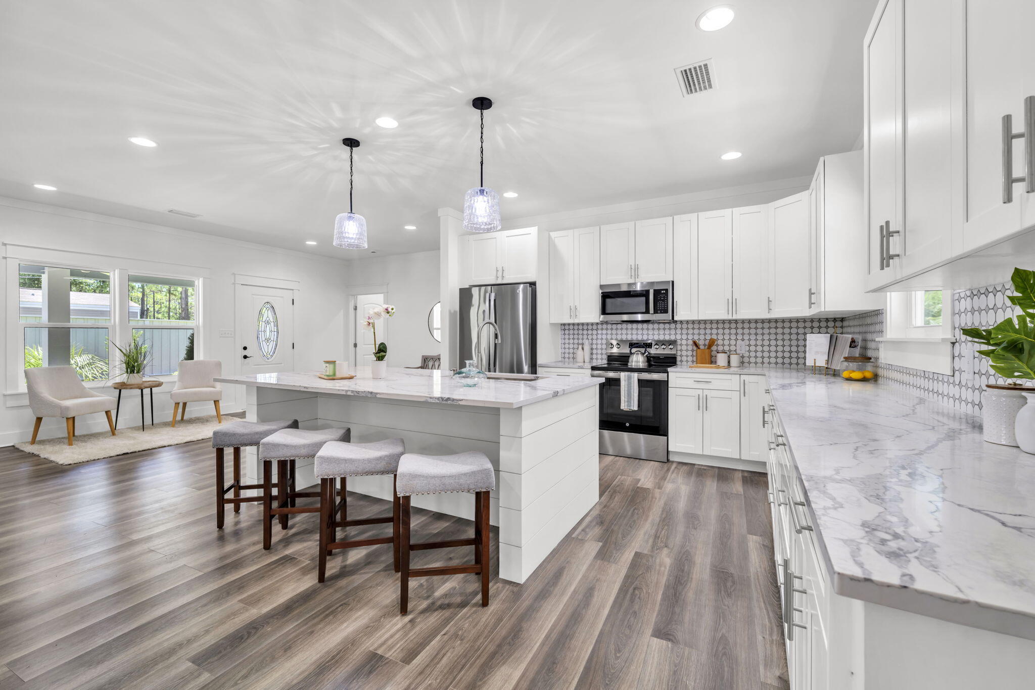 2672 Chat Holley Road Santa Rosa Beach, FL 32459 - Photo 19 of 53 a kitchen with stainless steel appliances granite countertop a stove top oven a sink dishwasher white cabinets and a dining table with wooden floor