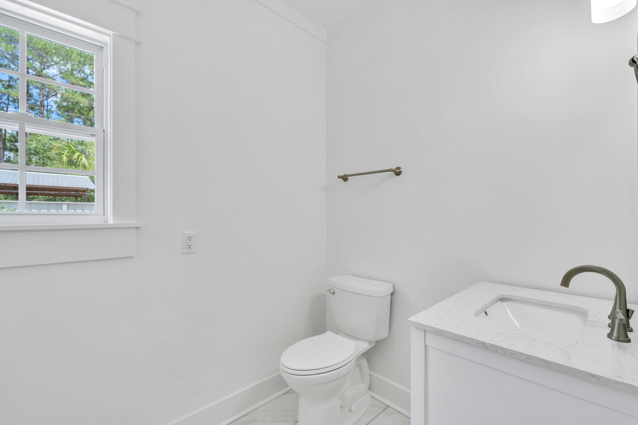 2672 Chat Holley Road Santa Rosa Beach, FL 32459 - Photo 32 of 53 a white toilet sitting next to a bathroom sink