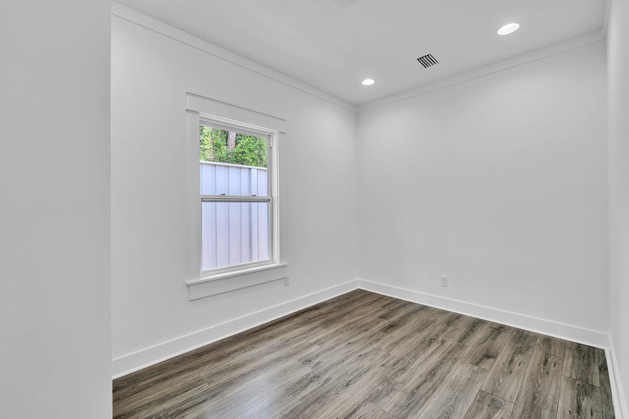 2672 Chat Holley Road Santa Rosa Beach, FL 32459 - Photo 36 of 53 an empty room with wooden floor and windows