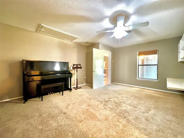 a view of a livingroom with a piano and wooden floor