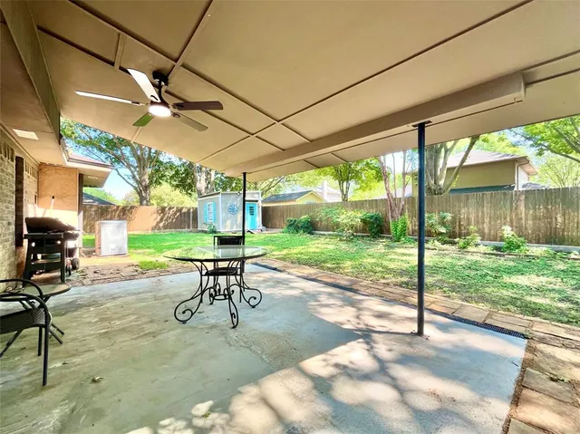 a view of a patio with a table chairs and backyard