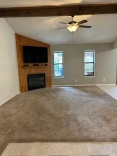 a view of an empty room with window and fireplace