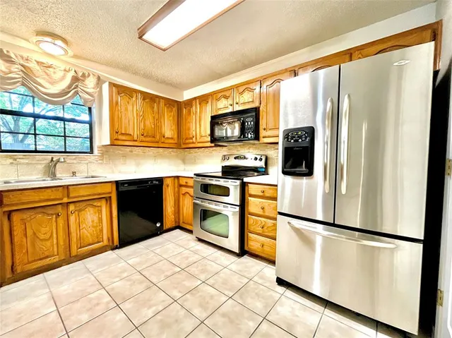 a kitchen with stainless steel appliances a refrigerator sink and cabinets