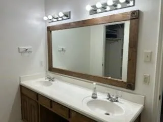 a bathroom with a double vanity sink and a mirror
