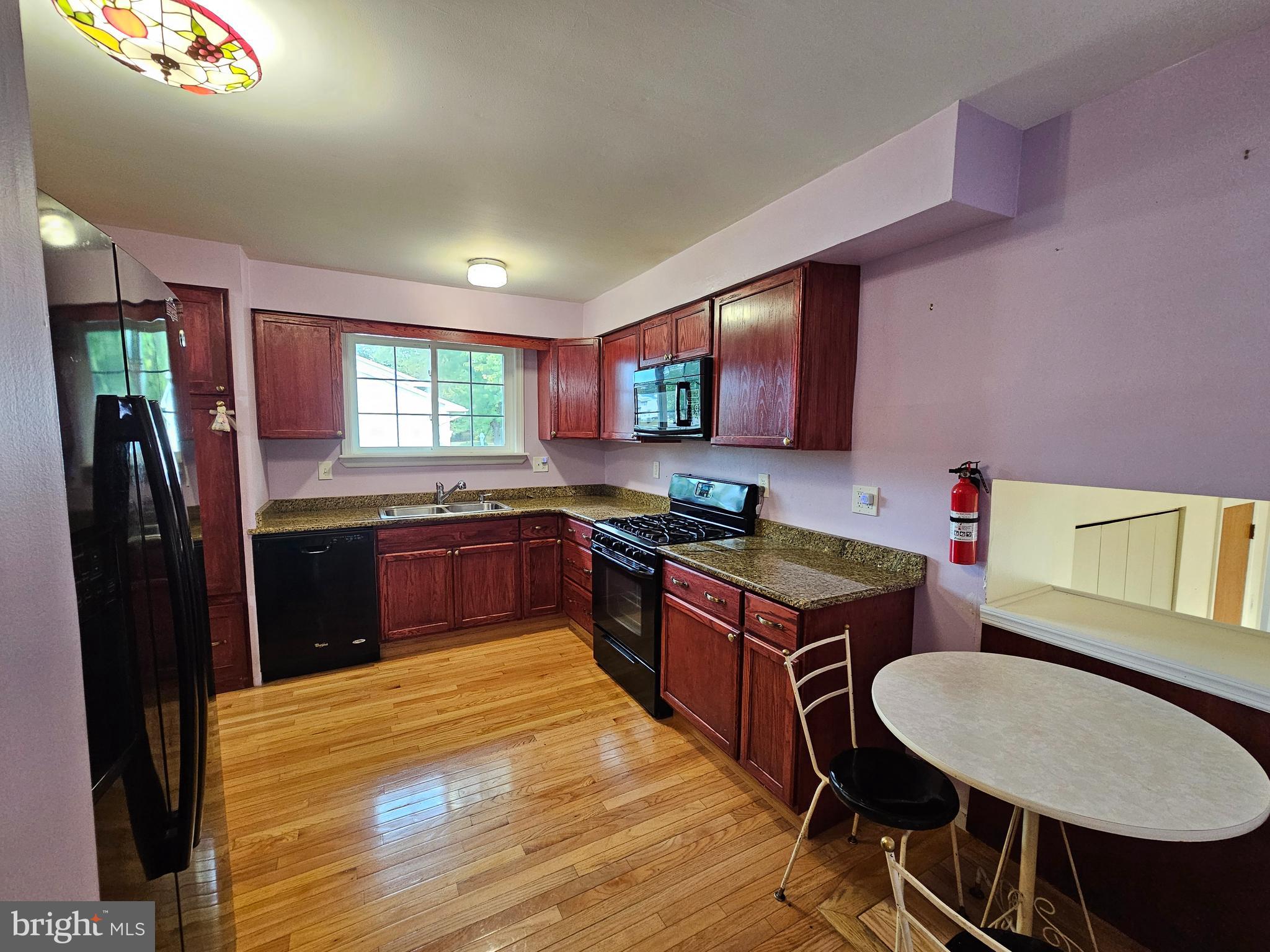 401 Cardinal Road Beverly, NJ 08010 - Photo 19 of 35 a kitchen with stainless steel appliances granite countertop a stove a sink dishwasher a refrigerator a microwave oven with white cabinets and wooden floor