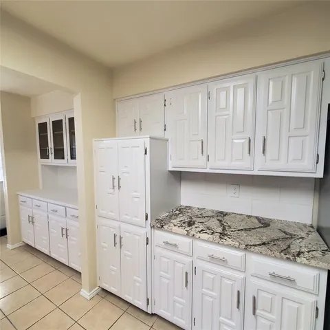 a kitchen with granite countertop a sink stove and cabinets