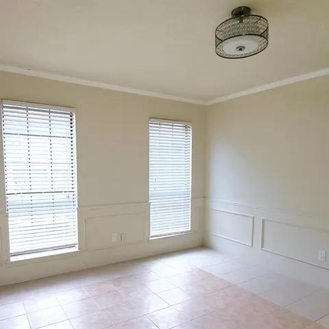 an empty room with windows and ceiling fan