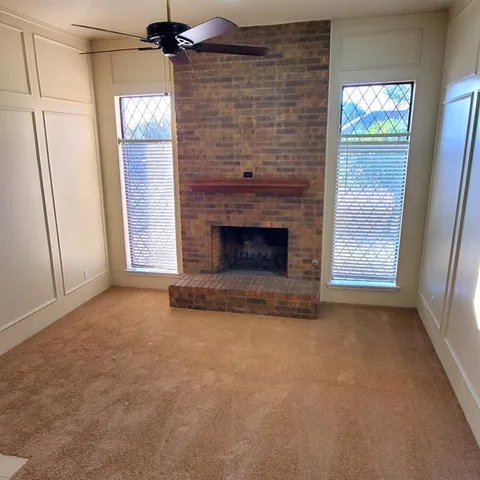 a view of empty room with fireplace and window