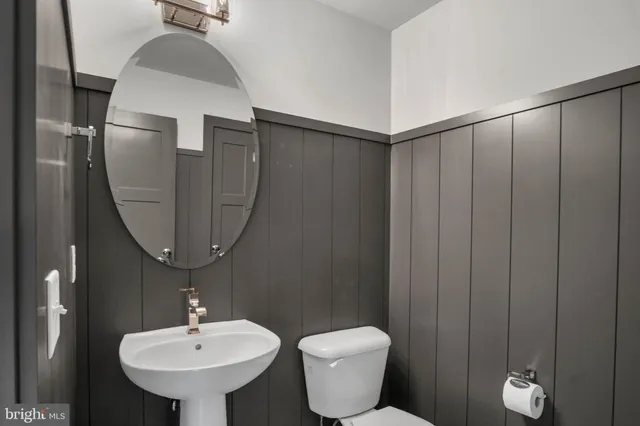 a bathroom with a toilet sink and mirror