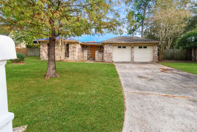 a front view of a house with a garden and trees