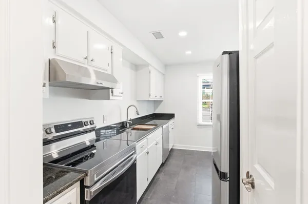 a kitchen with stainless steel appliances a sink stove and cabinets