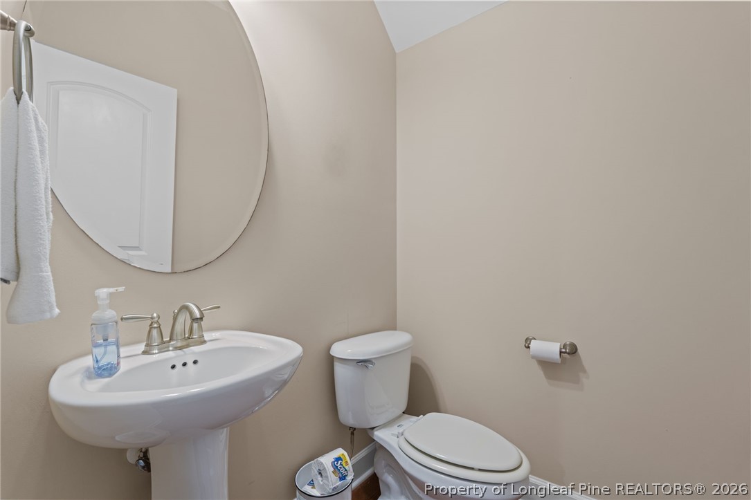 126 Pine Hawk Drive Spring Lake, NC 28390 - Photo 16 of 48 a bathroom with a sink a toilet and mirror