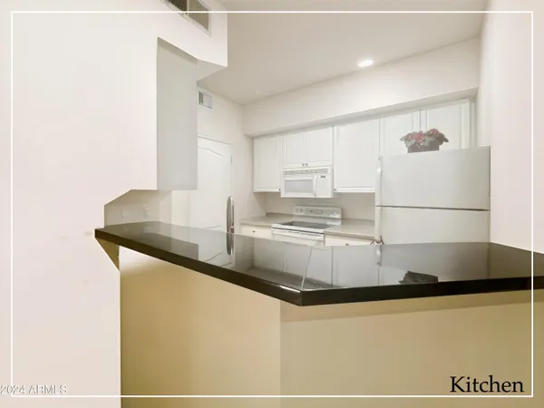 a kitchen with granite countertop a sink and a refrigerator