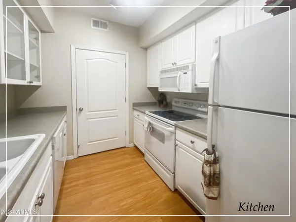 a kitchen with white cabinets and white appliances