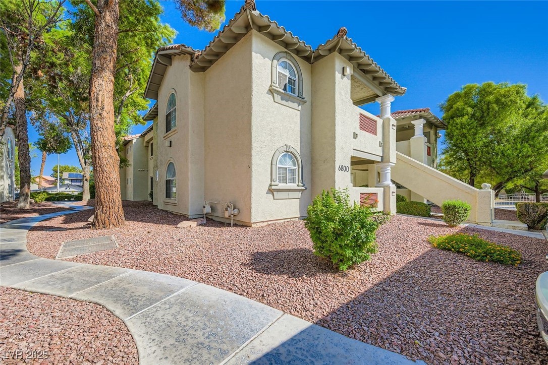 View of front of house with stucco siding and a tiled roof