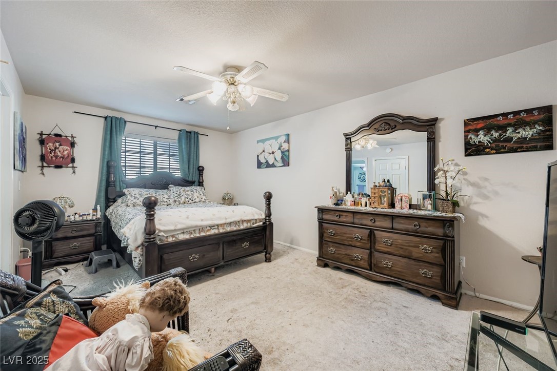 6800 West Elm Creek Drive, Unit 103 Las Vegas, NV 89108 - Photo 13 of 22 Bedroom featuring light carpet and ceiling fan