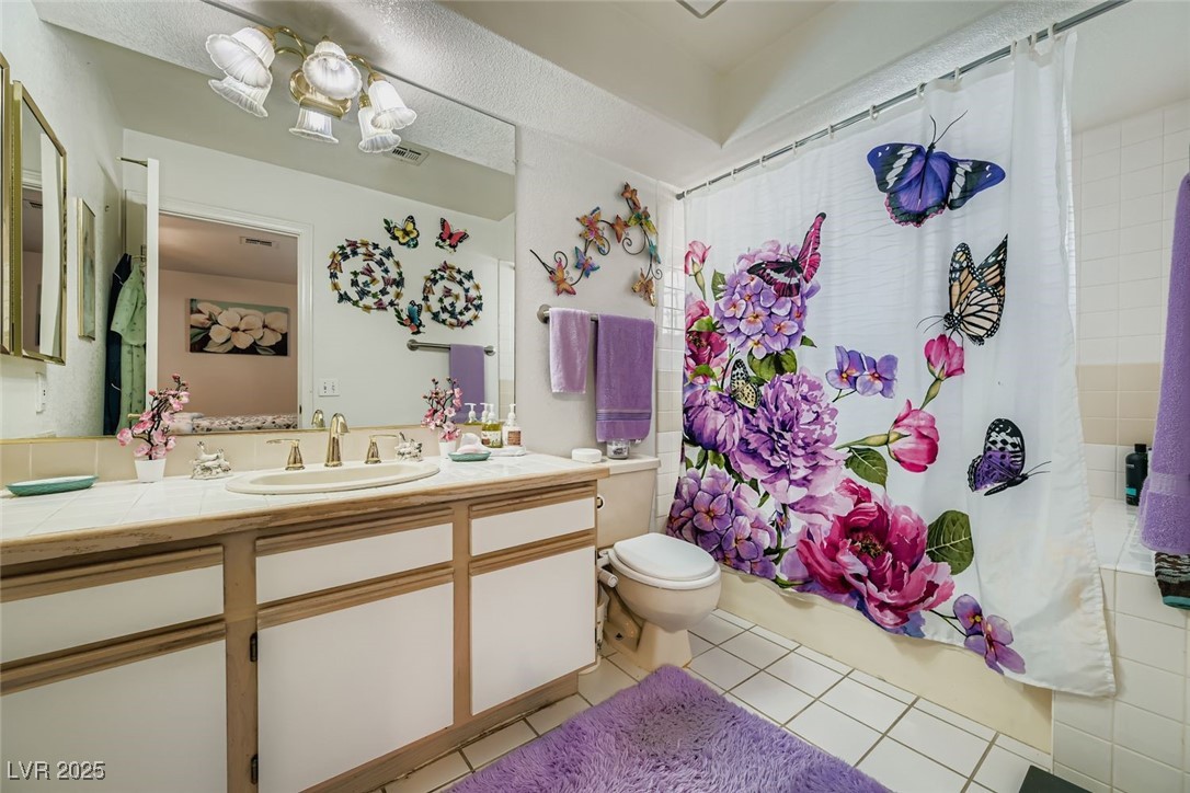 6800 West Elm Creek Drive, Unit 103 Las Vegas, NV 89108 - Photo 16 of 22 Bathroom featuring shower / bath combo with shower curtain, vanity, and light tile patterned flooring